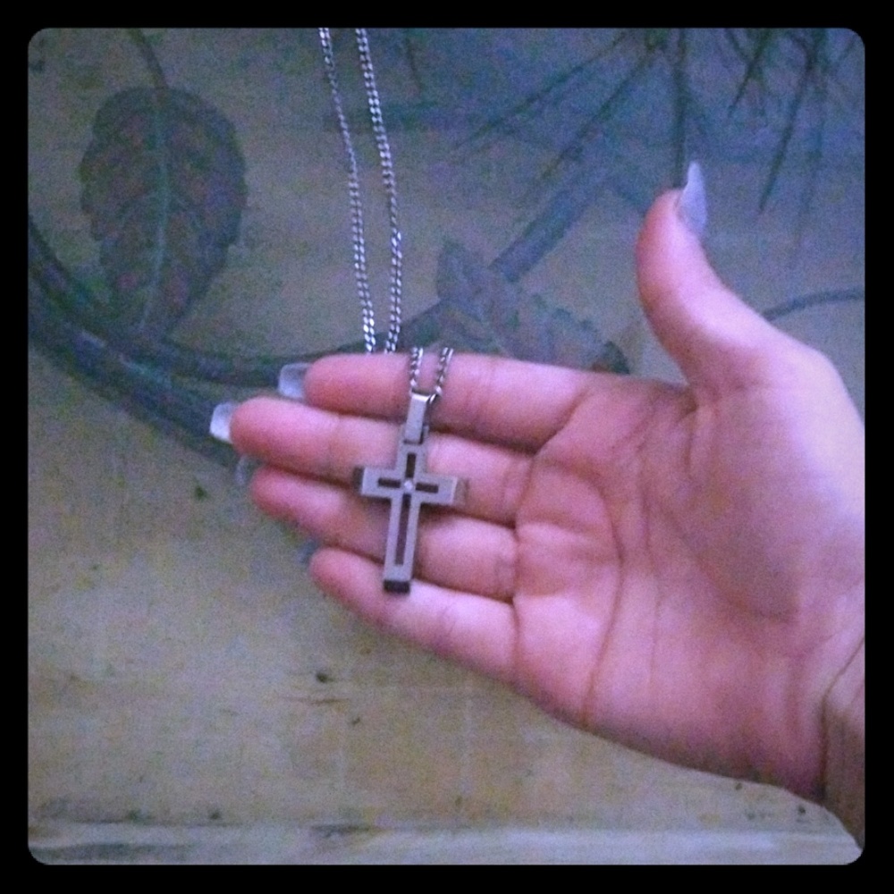 A silver chain with a cross on it. ✌